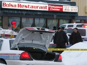 Police at the scene of the triple slaying in a Vietnamese restaurant in the Macleod Plaza strip mall on New Year's Day, 2009.