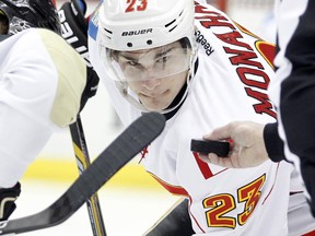 Sean Monahan #23 of the Calgary Flames takes a faceoff against Brandon Sutter #16 of the Pittsburgh Penguins during the game at Consol Energy Center on December 12, 2014 in Pittsburgh.