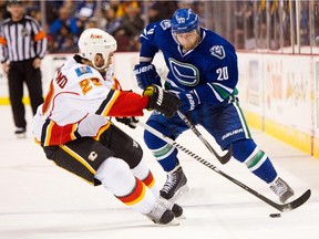 Chris Higgins #20 of the Vancouver Canucks tries to get past Deryk Engelland #29 of the Calgary Flames during the third period in NHL action in Vancouver, BC,  on December, 20, 2014 at Rogers Arena in Vancouver, British Columbia, Canada.