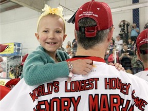 Little Diamond Marshall, held by her father Lyall Marshall, after the Hockey Marathon for the Kids in Chestermere, Alberta Wednesday, May 16, 2012. The event raised $1.4 million for the Alberta Children's Hospital Foundation, while setting a world record for the world's longest hockey game.