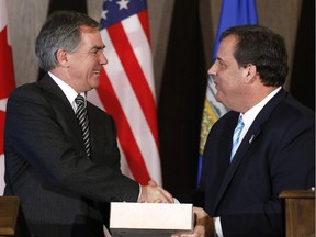 New Jersey Governor Chris Christie, right, is presented with a gift of Alberta beer by Alberta Premier Jim Prentice during a meeting in Calgary, Alberta on Thursday, Dec. 4, 2014.