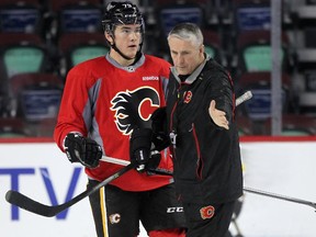 Calgary Flames left winger Michael Ferland gets instructions from head coach Bob Hartley as he skated with the team during practice at the Scotiabank Saddledome on December 5, 2014.