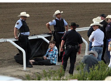 A protestor sat chained to the railing of the chuckwagon track prior to the Rangeland Derby at the Calgary Stampede on July 4, 2014. Two protestors managed to use bicycle chains around their necks. They were eventually cut free and taken into custody.