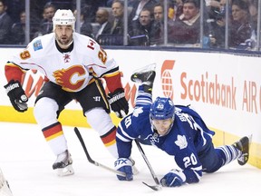 Toronto Maple Leafs forward David Booth (20) gets tripped up by Calgary Flames defenceman Deryk Engelland (29) during second period NHL hockey action in Toronto on Tuesday, December 9, 2014.