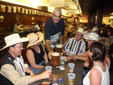 Morris Blitt, owner of the St. Louis Hotel, serves up a couple pitchers of beer to some of his Stampede regulars in 2006.