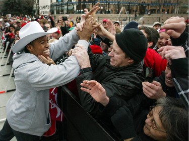 A Calgary Stampeders fan reaches out to touch quarterback Henry Burris as he greets the crowd at the Stampeder's Grey Cup celebration at Olympic Plaza in Calgary Tuesday, November 25, 2008.