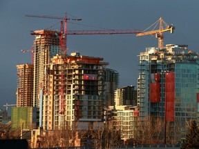 Residential condo construction projects in the East Village and in the distance Victoria Park are lit by the rising sun.