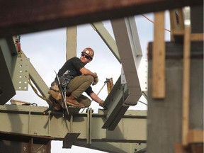 Ironworker Matt Adams helped keep an eye on guiding the last structural beam of the new National Music Centre into place on December 12, 2014. The structural framing is now done and the building is moving into enclosing and finishing to facility.