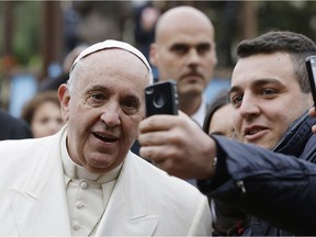 The faithful take selfies with Pope Francis as he visits Rome's St. Joseph's Church on Sunday. Reader says local bishops aren't following the Pope in their position on gay-straight alliances.
