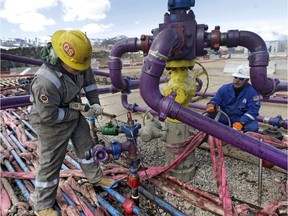 Workers tend to a well head at an Encana fracking gas well in western Colorado.