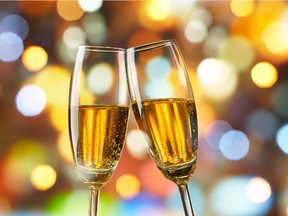 Champagne is a better choice than Bailey's or rum and eggnog if you're indulging over the Christmas holidays.
two glasses of champagne toasting against bokeh lights background