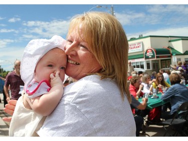 HIGH RIVER, ; JUNE 20,  2014  -- Tammy Beach holds onto her granddaughter Lainey Pollett, four months, as residents of High River came out on June 20, 2014 a year later to mark the anniversary of the flood that  devastated the community one year ago.