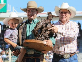 Dustin Flundra of Pincher Creek celebrates with the bronze trophy in the Calgary Stampede saddle bronc event back in July. His successful season continues at the National Finals Rodeo in Las Vegas, starting Thursday.