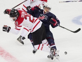 Canada forward Jonathan Drouin, left, takes out Team USA forward John Gaudreau, right, during first period semi-final IIHF World Junior Championships hockey action in Ufa, Russia on Thursday, Jan. 3, 2013. The Americans got the last laugh, though, with a 5-1 win.