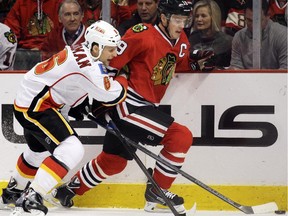 Chicago Blackhawks centre Jonathan Toews controls the puck against Calgary Flames defenceman Dennis Wideman during the second period on Sunday.