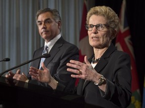 Ontario Premier Kathleen Wynne, right, and Alberta Premier Jim Prentice speak to reporters in Toronto on Dec. 3, 2014.