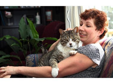 JUNE 4,  2014  --  Ev Neighbour of High River was reunited with her cat Satan, 13, on Monday. He went missing from a home he was staying at during the floods last June only to show up on his old window still almost a year later.