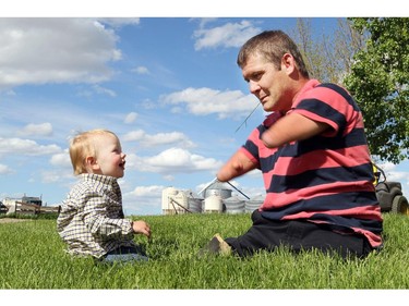 NANTON, ; JUNE 1,  2014  -- Chris Koch of Nanton shares a blade of grass with his nephew Brayden, he has become an internet sensation after a film shot by John Chester featuring him was broadcast on the Oprah Winfrey show. He was born without arms or legs but that hasn't slowed him down at all.
