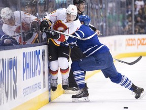 Toronto Maple Leafs defenceman Cody Franson, right, hits Calgary Flames forward Mason Raymond  during the first period on Tuesday.