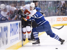 Toronto Maple Leafs defenceman Cody Franson, right, hits Calgary Flames forward Mason Raymond (21) during first period NHL hockey action in Toronto on Tuesday, December 9, 2014.