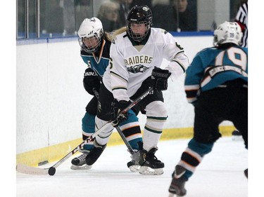 Rocky Mountain Raiders forward Kara Kondrat, centre, carried the puck down the ice against  Battleford Sharks defenceman Taylor Fiske, left, during their Mac's AAA Midget Female Division game at the Max Bell Arena on December 26, 2014.