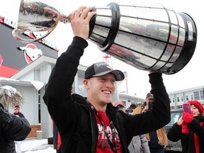 Quarterback Bo Levi Mitchell lifts the cup as the Grey Cup-champion Stampeders returned to Calgary Monday.