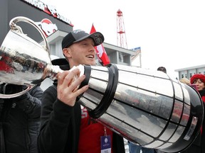 Quarterback Bo Levi Mitchell lifts the trophy as the Grey Cup champion Stampeders returned to Calgary on Monday.