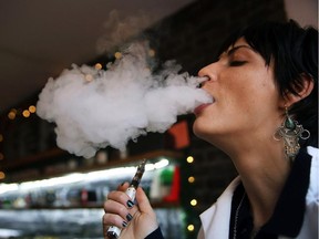 Catharine Candelario, an employee at Henley Vaporium, vapes, or smokes an electronic cigarette, on Dec. 19, 2013 in New York City.