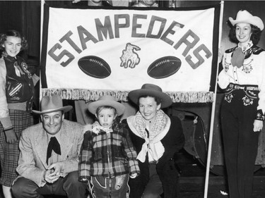 NOV 24, 1948 - Fans pose in front of the train that is heading to Toronto for the Grey Cup between the Calgary Stampeders and the Ottawa Rough Riders. Those shown , above the banner, in the train, are (top to bottom, left to right) Mr. And Mrs. W.J. Sanford, Fred Harris, Mrs. Merv Cozart, Bill Harris, Merv Cozart and Archie Currie; (beside banner), Carole Adams, Stewart Adams, Paulette Price, 4, youngest train traveler, Mrs Larry Price and Isabel McRae.