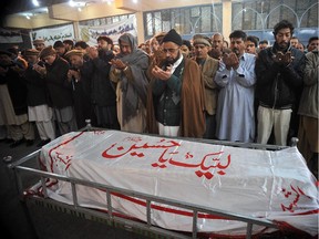 Pakistani mourners pray over the coffin of a student following an attack by Taliban gunmen on a school in Peshawar on December 16, 2014. Taliban insurgents stormed an army-run school in Pakistan, killing at least 141 people, almost all of them children, in Pakistan's bloodiest ever terror attack.