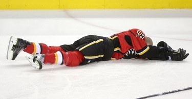 Calgary Flames Matt Stajan lies on the ice after colliding with Edmonton Oilers Keith Aulie during their game at the Scotiabank Saddledome in Calgary on December 31, 2014.