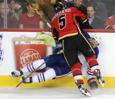 Calgary Flames Mark Giordano collides with  Edmonton Oilers Ryan Nugent-Hopkins during their game at the Scotiabank Saddledome in Calgary on December 31, 2014.