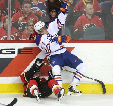 Calgary Flames TJ Brodie collides with Edmonton Oilers David Perron, right, during their game at the Scotiabank Saddledome in Calgary on December 31, 2014.