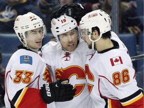 Calgary Flames' Raphael Diaz, left, and Josh Jooris celebrate with David Jones after he scored against Buffalo in the second period. Diaz drew into the lineup as the club looks to shake up their third defensive pairing.