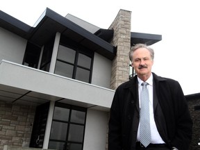 Realtor Lowell Martens poses outside of a luxury home in Calgary on April 29, 2013.