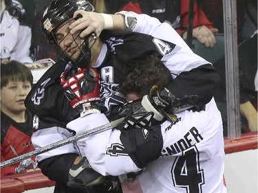 Calgary Roughnecks' Geoff Snider takes on Edmonton Rush's Kyle Rubisch during an exhibition game at the Saddledome in Calgary, on December 20, 2014.