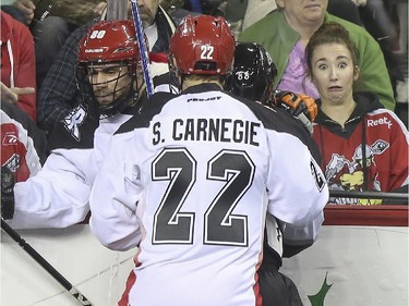 A Calgary Roughnecks gets a surprisingly close view of a tangled check into the boards as Scott Carnegie, 22, hits Edmonton Rush's Zack Greer, 88, and Roughnecks' Peter McFetridge tries to get out of the way during exhibition game action at the Saddledome in Calgary, on December 20, 2014.