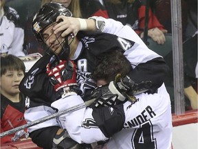 Calgary Roughnecks' Geoff Snider takes on Edmonton Rush's Kyle Rubisch during an exhibition game at the Saddledome ion Saturday.