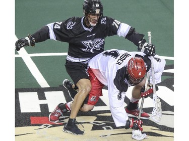 Calgary Roughnecks Geoff Snider and Edmonton Rush's Jeremy Thompson wrestle for the ball during exhibition game action at the Saddledome in Calgary, on December 20, 2014.