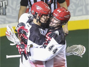 Calgary Roughnecks' Karsen Leung, left, celebrates scoring the teams first goal of the game with teammate Dane Dobbie during exhibition game action against the Edmonton Rush at the Saddledome in Calgary, on December 20, 2014.