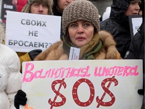 A protester holds a banner reading "Foreign currency mortgages - SOS" during a rally against the banks and the growth of the dollar in Moscow on Dec. 28, 2014.