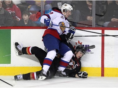 Calgary Hitmen left winger Kenton Helgesen was driven into the boards by Edmonton Oil Kings left winger Brandon Ralph during first period WHL action at the Scotiabank Saddledome on December 17, 2014.