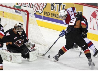 Calgary Hitmen goalie Mack Shields, left, keeps an eye on Edmonton Oil Kings centre Brett Pollock as Hitmen centre Adam Tambellini provided some support during first period WHL action at the Scotiabank Saddledome on December 17, 2014.