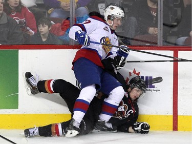 Calgary Hitmen left winger Kenton Helgesen was driven into the boards by Edmonton Oil Kings left winger Brandon Ralph during first period WHL action at the Scotiabank Saddledome on December 17, 2014.