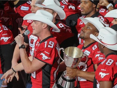 Nik Lewis, right, looks up with the Grey Cup at the scoreboard as he and the rest of the Calgary Stampeders were honoured before the Calgary Flames faced off against the Arizona Coyotes at Scotiabank Saddledome in Calgary on Tuesday December 2, 2014.