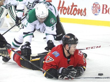 Lance Bouma of the Calgary Flames is knocked to the ice by Jamie Oleksiak of the Dallas Stars in the Dallas zone during the first period at the Saddledome Friday night December 19, 2014.