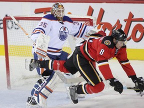 Calgary Flames forward Joe Colborne, right, collides with Edmonton Oilers goalie Viktor Fasth during first period action at the Scotiabank Saddledome in Calgary on December 27, 2014.