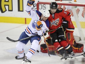 Calgary Flames Raphael Diaz, right and Edmonton Oilers Matt Hendricks collide during second period action at the Scotiabank Saddledome in Calgary.