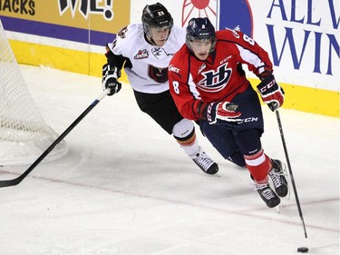 Calgary Hitmen left winger Elliott Peterson gave chase to Lethbridge Hurricanes defenceman Bryton Sayers during WHL action at the Scotiabank Saddledome on December 30, 2014.