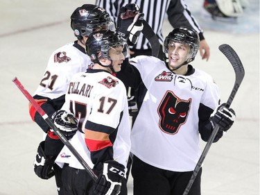 Members of the Calgary Hitmen, from left, centre Terrell Draude, centre Jordy Stallard and left winger Taylor Sandheim celebrated after they scored against the Lethbridge Hurricanes during WHL action at the Scotiabank Saddledome on December 30, 2014.